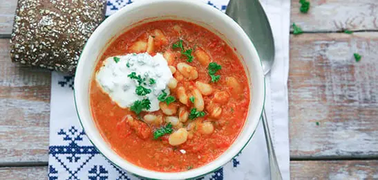 Recept van het Voedingscentrum: Tomatensoep met boontjes en peterselietopping