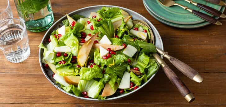 Recept van het Voedingscentrum: Groene salade met andijvie, gebakken peer en granaatappel